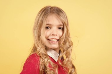 Turuncu arka planda kıvırcık sarı saçlı çocuk.