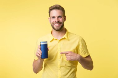 Saç modelin için en iyi şampuan. Saçları daha güçlü ve daha esnek yap. Yakışıklı sakallı hippi plastik şişe şampuanı ya da duş jeli tutuyor. Saç bakım konsepti. Etkili şampuan. Bu şampuanı dene.