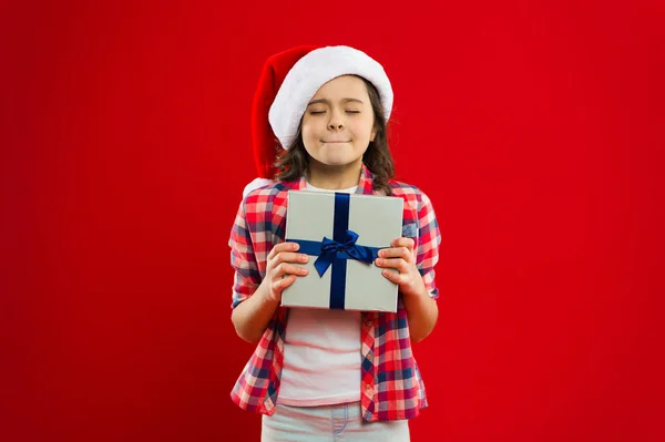 Regalo para Navidad. Infancia. Compras de Navidad. Fiesta de año nuevo. Chico Santa Claus. Niña con sombrero rojo de santa. Felices fiestas de invierno. Niña pequeña. Hazlo juntos. Programa de vacaciones — Foto de Stock