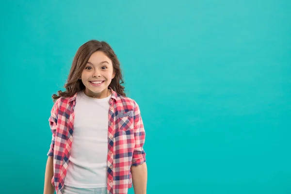 Sincere excitement. Kid girl long healthy shiny hair wear casual clothes. Exciting moments. Little girl excited happy face. Kid happy cute face feels excited blue background. Excitement emotion