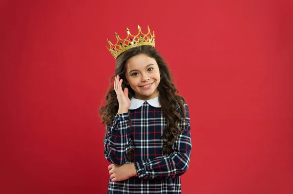 A elegância fica-lhe bem. Kid usar símbolo coroa de ouro da princesa. Toda garota sonhando em se tornar princesa. Lady princesinha. Menina usar coroa fundo vermelho. Conceito de família monarca. Maneiras de princesa — Fotografia de Stock