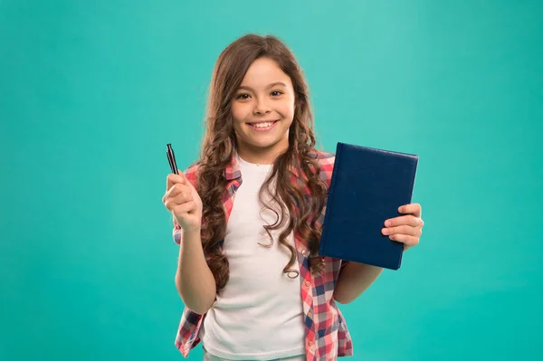Я готов к школе. Умный ребенок держит ручку и блокнот. Девушка милая счастливое лицо любит изучать синий фон. Девочка держит в руках книгу и ручку. Вернемся к школьной концепции. Школьное задание — стоковое фото
