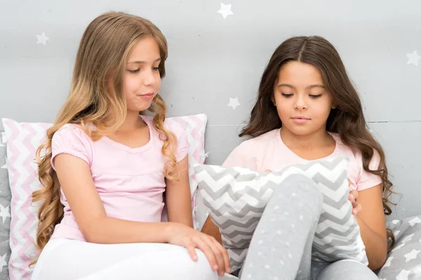 Sisters communication. Girls in cute pajamas spend time together in bedroom. Sisters communicate while relax in bedroom. Family time. Children relax and having fun in evening. Sisters leisure — Stock Photo, Image