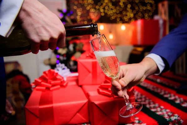 Drinken champagne of mousserende wijn. Vieren Nieuwjaar met champagne. Cheers concept. Handen gieten van champagne in elegante glazen Kerst decoraties achtergrond. Last minute voor Nieuwjaar — Stockfoto