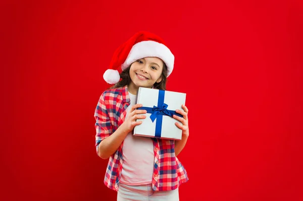 Niña con sombrero rojo de santa. Compras de Navidad. Regalo para Navidad. Infancia. Fiesta de año nuevo. Chico Santa Claus. Felices fiestas de invierno. Niña pequeña. Abriendo su regalo de Navidad —  Fotos de Stock