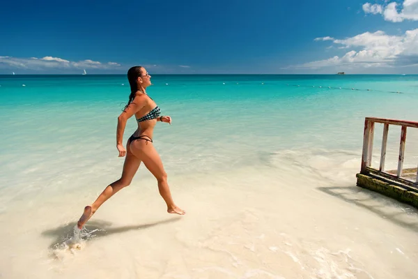 Chica con cuerpo sexy en bikini corriendo en la playa —  Fotos de Stock