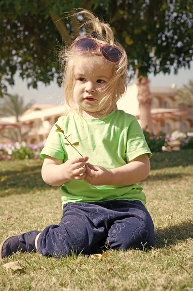 Niño pequeño con cara adorable en hierba verde —  Fotos de Stock