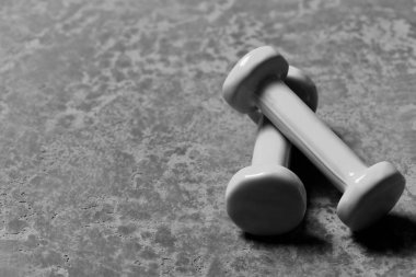 Halterler çaprazlama yerleştirilmiş. Cyan plastiğinden yapılmış dambıllar