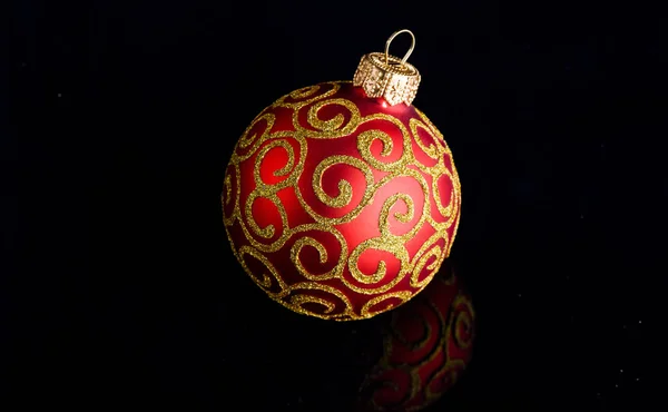 Pick decor for christmas tree. Christmas ornament single red ball on black background. Christmas ornament concept. Elegant and luxury christmas decor close up. Ball ornament on black surface — Stock Photo, Image