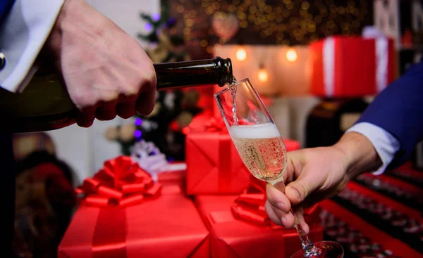 Laatste minuut voor Nieuwjaar. Drink champagne of mousserende wijn. Vier Nieuwjaar met champagne. Proost concept. handen gieten champagne in elegante glas kerst decoraties achtergrond — Stockfoto