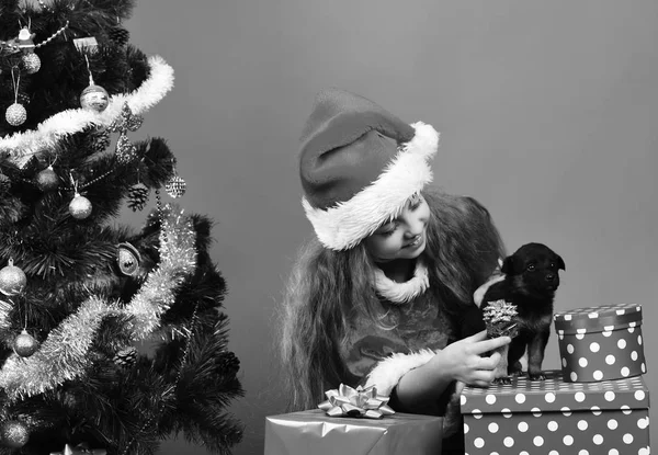 Niño con cara feliz unpacks da regalos sobre fondo rojo —  Fotos de Stock