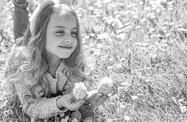 Kind mit niedlichen Hasenohren auf der Wiese liegend. Niedliche Kind lag auf Gras mit Ei in den Händen. kleines Mädchen auf Ostereiersuche im Frühlingsgarten am Ostertag, traditionelles Fest. Osterfest-Konzept — Stockfoto