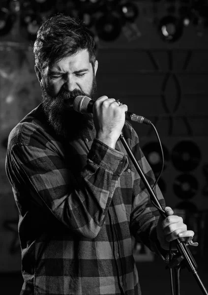 Homem com cara entusiasta segura microfone, cantando música , — Fotografia de Stock