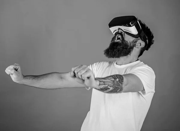 Mann mit Bart in vr Brille Motorrad fahren, roter Hintergrund. Hipster auf aufgeregtem Gesicht fahren Fahrrad mit hoher Geschwindigkeit in virtueller Realität mit modernem digitalen Gadget. Konzept virtueller Fahrstunden — Stockfoto