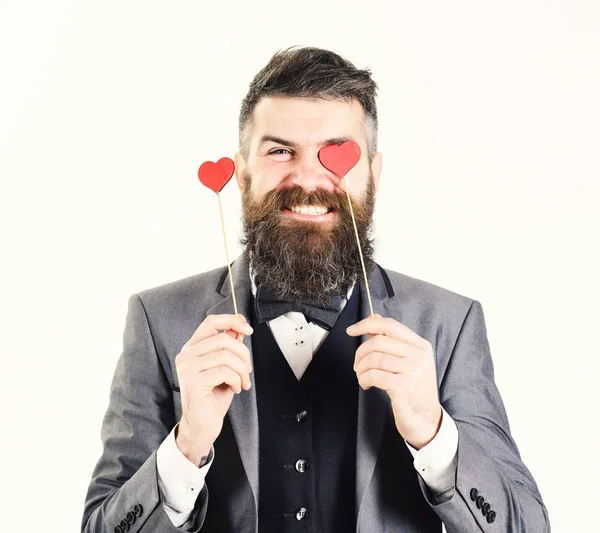 Feliz homem sorridente com pequenos corações vermelhos em paus . — Fotografia de Stock