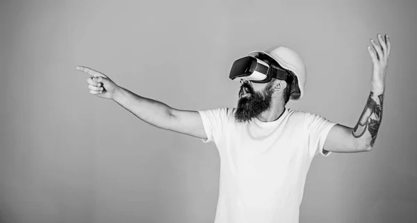 Hipster dans le casque fonctionne comme ingénieur en réalité virtuelle. Concept de conception 3D. Architecte ou ingénieur avec lunettes de réalité virtuelle. Homme barbe en lunettes VR pointant du doigt, fond bleu clair — Photo