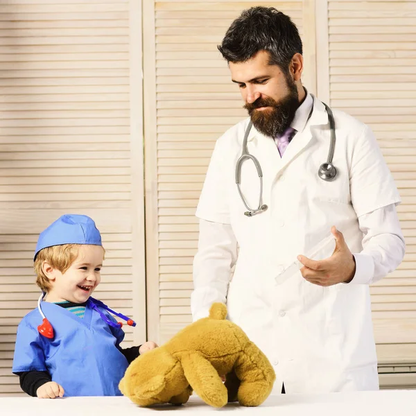 Padre e hijo con caras sonrientes jugando al doctor. —  Fotos de Stock