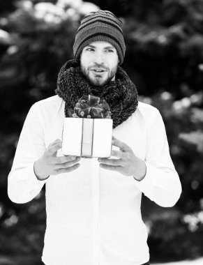 Kışın açık havada hediye kutusu olan yakışıklı bir adam.
