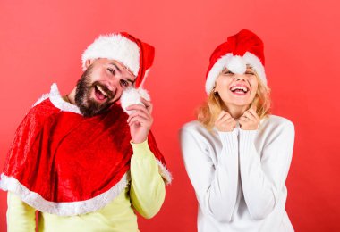 Çift kutlamak kış tatil Noel partisi. Sakal ve kadın santa şapka kırmızı arka planı olan adam. Noel maskeli balo karnival kavramı. Çift neşeli yüzü Noel kutlaması. Noel Baba kostüm Kiralama