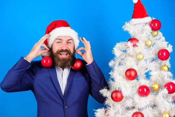 Christmas fun. Man bearded hipster wear formal suit and santa hat. Business and christmas concept. Santa hold christmas ball decoration. Holidays meant for fun. Businessman join christmas preparation