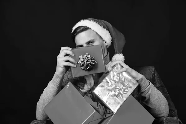Siyah arka planda hediyeleri olan Noel Baba. Utangaç yüzlü adam. — Stok fotoğraf