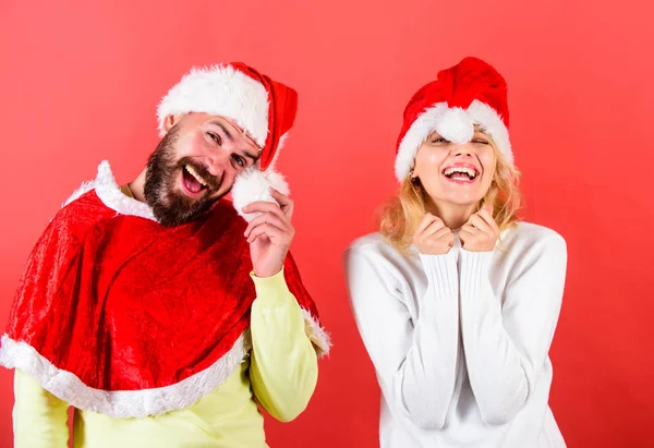 Par fira vinter semester julfest. Mannen med skägg och kvinna santa hatt röd bakgrund. Christmas maskerad karnival koncept. Par glada ansikte fira jul. Hyra santa dräkt — Stockfoto