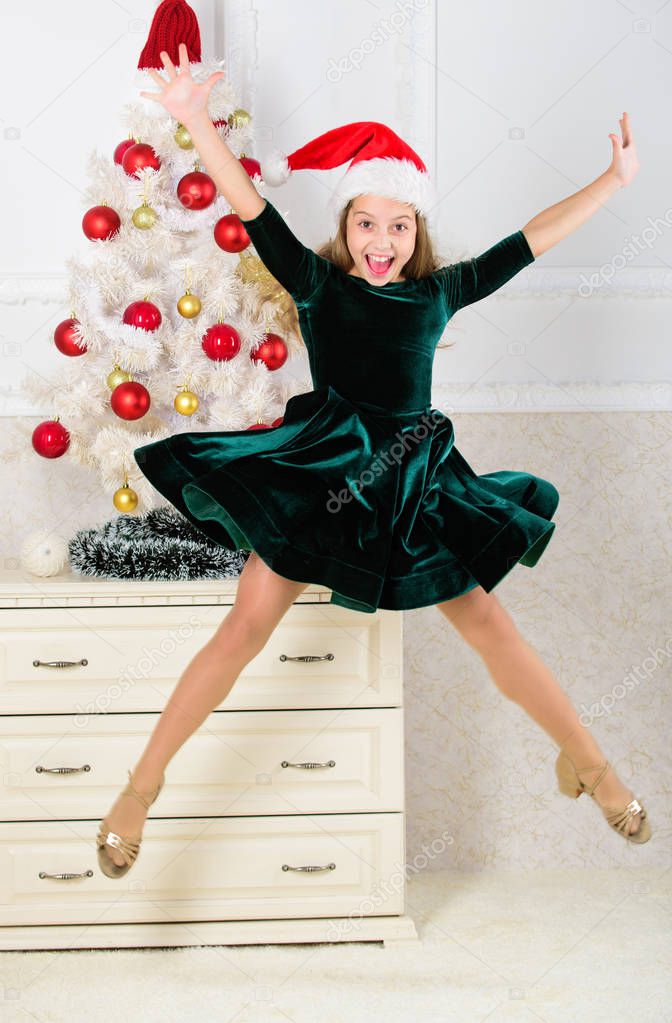 Child emotional cant stop her feelings. Celebrate christmas concept. Girl in dress jumping. It is christmas. Day we have waited for all year finally here. Girl excited about christmas jump mid air