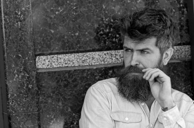 Sakal ve bıyık konsantre yüzünde siyah mermer zemin üzerine olan adam. Adam baktılar ve meraklı görünüyor. Erkeklik kavramı. Tousled saçlı hippi bıyık mesafe içine bakarken katlanmış