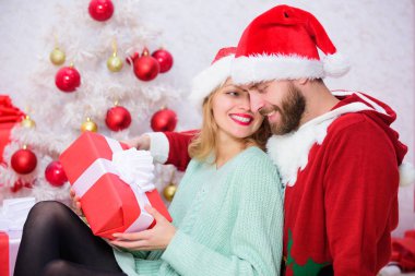 Birlikte Noel kutluyor. Sevgi dolu çift hediyeler Noel ağacı arka plan ile açma sırasında gülümseyerek sarıl. Aile Noel geleneği. Aşık çift Noel tatil kutlaması tadını çıkarın.