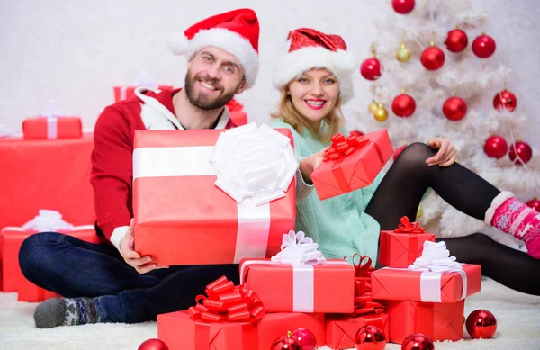 Love is best gift. Family married couple at home. Couple in love enjoy winter holiday celebration. Woman and bearded man in love sit near christmas tree background. Christmas eve with darling