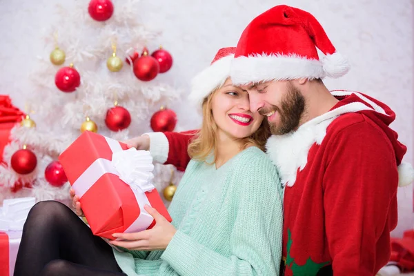 Γιορτάζει τα Χριστούγεννα μαζί. Αγάπη ζευγάρι αγκαλιά χαμογελώντας κατά την αποσυμπίεση τα δώρα με φόντο χριστουγεννιάτικο δέντρο. Οικογενειακή παράδοση των Χριστουγέννων. Ερωτευμένο ζευγάρι απολαύσετε εορτασμός διακοπών Χριστουγέννων — Φωτογραφία Αρχείου