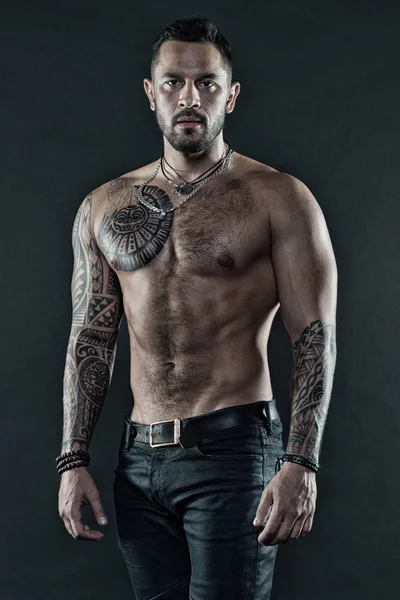 Masculinidad y brutalidad. Concepto de cultura del tatuaje. Atributo brutal del tatuaje. Hombre brutal sin afeitar aspecto hispano tatuado brazos. El hombre barbudo muestra el torso tatuado. Brutal estricto macho con tatuajes — Foto de Stock