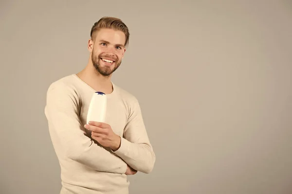 Sonrisa de soltero con champú o botella de gel en la mano, higiene — Foto de Stock