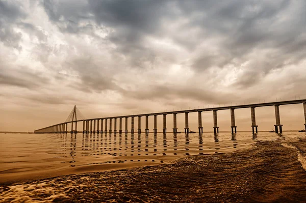 Most přes moře v manaus, Brazílie. Silniční průjezd nad vodou na zatažené obloze. Architektura a design. Cíl cesty a toulavost — Stock fotografie