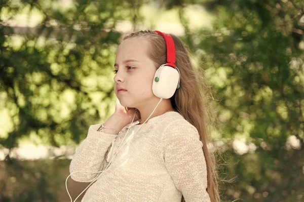 Милая маленькая девочка наслаждается музыкой в наушниках — стоковое фото