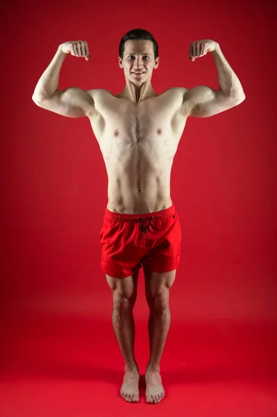 Strength and motivation. fit your body and lose weight. Sport and fitness. Athlete or sportsman in red shorts. Athlete warming up before workout. Muscular man with strong body. man exercising in gym