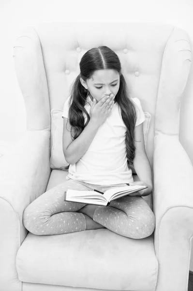 Entusiástico com a história emocionante. A ler passatempo. Menina criança sentar poltrona amarelo ler livro. Criança bicho de biblioteca bonito. Menina garoto bonito pijama relaxar ler livro de contos de fadas antes de dormir. Incentivar hábitos úteis — Fotografia de Stock