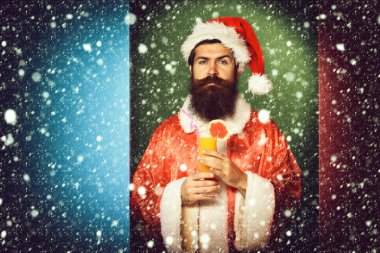 ciddi yüz Noel veya xmas kazak ve renkli stüdyo arka plan, kopya spac yeni yıl şapkası Alkolsüz kokteyl bardak tutan uzun sakallı yakışıklı Noel Baba adam sakallı