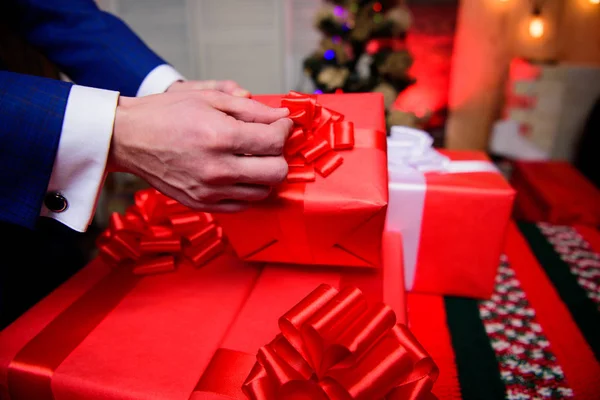 Wrapping gifts concept. Magic moments. Prepare surprise gifts for family and friends. Gift boxes with big ribbon bow close up. Red wrapped gifts or presents. Prepare for christmas and new year