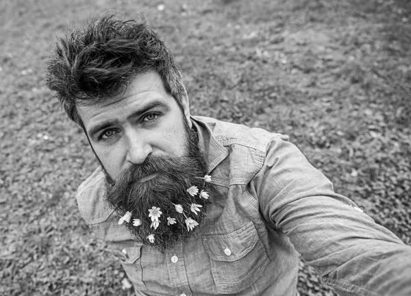 Salátaboglárka virágok szakáll selfie fénykép srác. Csípő nyugodt arc selfie fénykép. Férfi szakállal élvezi a tavasz, zöld rét háttér, defocused. Természetes szépség fogalma — Stock Fotó