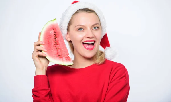 女圣诞老人的帽子拿着切片西瓜。漫长的夏天。旅游圣诞节度假度假胜地。美味的圣诞节概念。圣诞节夏季目的地。圣诞女孩吃西瓜 — 图库照片
