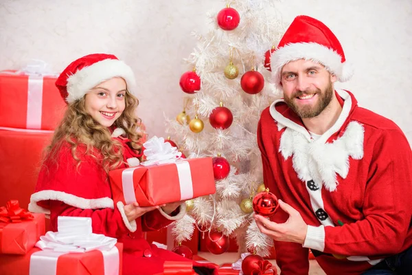 Christmas gift for child. Dad in santa costume give gift to daughter cute kid. Happy childhood. Christmas family holiday. Make your childs holiday extra special this year. Father christmas concept