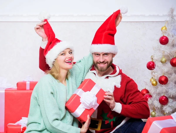 Concepto divertido de Navidad. Pareja enamorada disfrutar de la celebración de Navidad. Pareja usar sombreros como Santa Claus fondo del árbol de Navidad. Es fácil difundir la felicidad alrededor. Familia feliz celebrar la Navidad — Foto de Stock