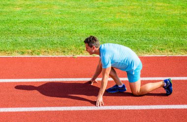 Yetişkin runner yarış Stadyumu'nda hazırlayın. Nasıl yayınlanmaya başlaması. Spor motivasyon kavramı. Adam atlet runner standı düşük başlangıç pozisyonu stadyum yolu güneşli bir gün. Runner gitmeye hazır. Zafer için çaba