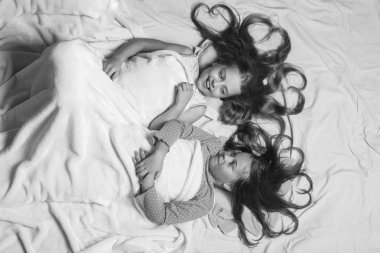 Beyaz battaniye altında Pembe pijama çocuklar. Gülümsüyor çocuklarla