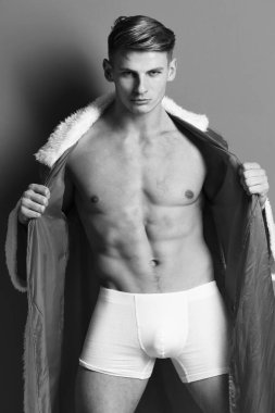 Seksi, kaslı, atletik güçlü vücudu olan genç, maço Noel Baba 'nın çıplak gövdesi ve güçlü bir göbeği vardır.