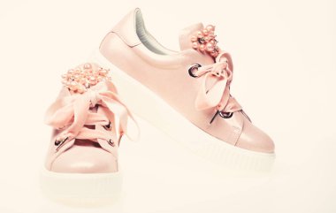 Göz alıcı spor ayakkabı kavramı. Şirin ayakkabılar beyaz arka plan üzerinde izole. Kadife kurdela ile soluk pembe kadın spor ayakkabı çifti. Ayakkabı kız ve kadınlar için inci boncuklar ile dekore edilmiştir.