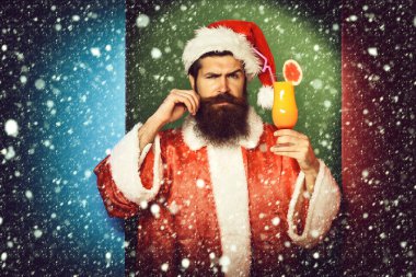 ciddi yüz alkolsüz kokteyl bardak Noel veya xmas kazak ve yeni yıl şapkası renkli stüdyo arka planda tutarak uzun sakallı yakışıklı Noel Baba adam sakallı