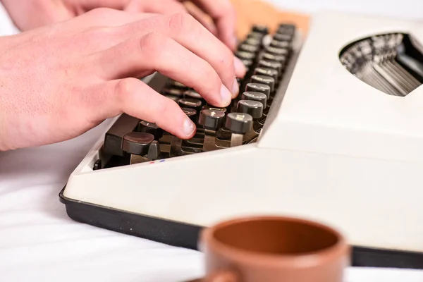 Het schrijven van routine. Vintage typemachine concept. Handen te typen retro schrijven machine. Oude schrijfmachine en auteurs handen. Mannelijke handen type verhaal of rapport met behulp van witte vintage typemachine apparatuur close-up — Stockfoto