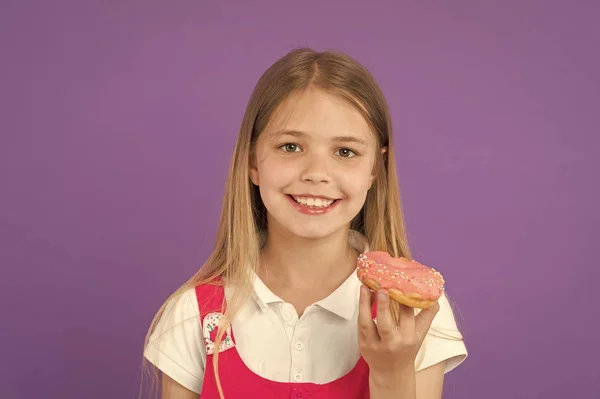 Criança sorrir com donut em fundo violeta. Menina com donut de anel envidraçado. Rapaz feliz com comida de plástico no fundo roxo. Comida e sobremesa. Infância e acolhimento de crianças — Fotografia de Stock